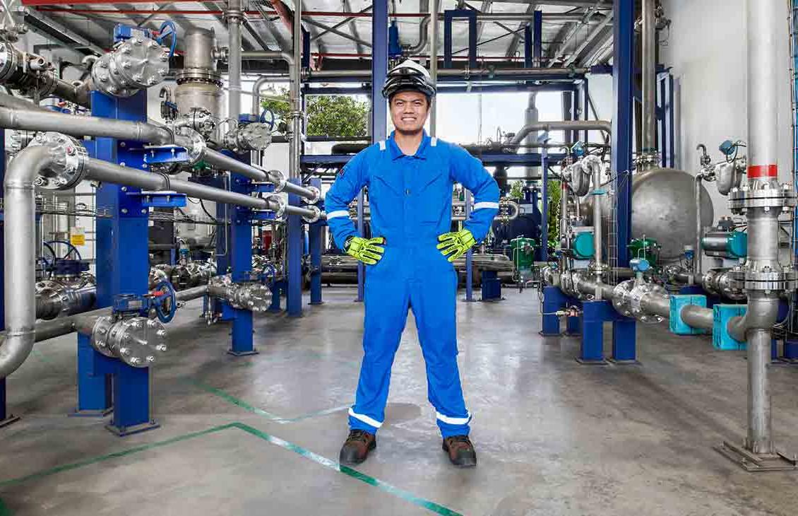 身穿蓝色工作服的男子站在工厂内(Tier 1_manufacingfacility_singapore_asia_15881)